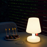 Edison The Petit Table Lamp - White, lit on an outdoor table