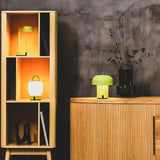 Fokus Battery Table Lamp - Moss, in a bookcase