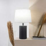 Jatobá Table Lamp by Geo Contemporary in Graphite with a White shade, lit, on a console