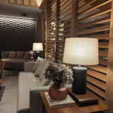 Jatobá Table Lamp by Geo Contemporary in Graphite with a Rustic Linen shade in a slatted-wood living room