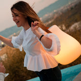 Kurby Play Portable Lamp - carried by its strap, orange glow