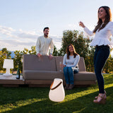 Kurby Play Portable Lamp - on a lawn beside a sofa