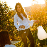 Kurby Play Portable Lamp - lit in a garden at sunset