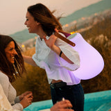 Kurby Play Portable Lamp - carried by its strap, purple glow