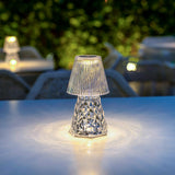 Lola Lux Table Lamp - lit on a terrace table