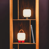 Loome Battery Table Lamp - Orange and Anthracite, in a bookcase