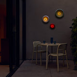 Oloha Table and Wall Lamp - lit on a terrace wall at night