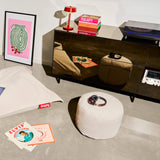 Point Recycled Cord Pouf Ottoman - Cream, beside a sideboard