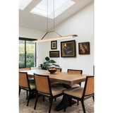 Penna Linear Pendant by Cerno over a wood dining table under skylights