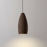 Seth Ceramic Pendant Light by Geo Contemporary in Desert, lit against a grey studio wall