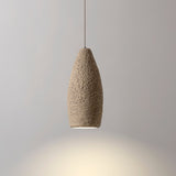 Seth Ceramic Pendant Light by Geo Contemporary in Ivory, lit against a grey studio wall