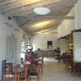Sunset Ceramic Pendant Light by Geo Contemporary in White, pendants lit along a rustic beamed dining hall