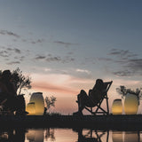 Synergy Battery Wine Cooler Lamp - lit on a terrace at dusk
