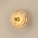 Wave Wall Light by Aromas Del Campo, lit, glowing through the alabaster disc