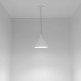 Zoe Ceramic Pendant Light by Geo Contemporary in White, lit in an empty grey room