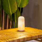 Candy Portable Table Lamp - lit on a rattan table