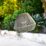 Conta Portable Pendant Light - Taupe, hanging in a garden