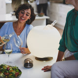 Sphere Battery Wine Cooler Lamp - Brass, at a dinner table