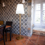 Lola Slim Floor Lamp - Brass, by a dining table