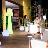 Lola Floor Lamp - 3000K, by an outdoor lounge