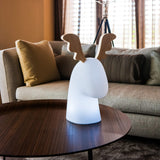 Rudy Reindeer Table Lamp - Solar and Rechargeable, white light on a coffee table