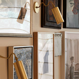 Bea Wall Sconce By Mitzi - Aged Brass on Wall around Portraits