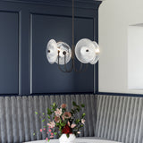 Hera Chandelier by Alora Mood - Matte Black/Clear Ribbed Glass hanging above on the table