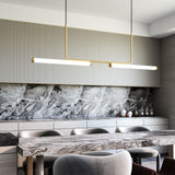 Vesper Linear Suspension By Kuzco - Brushed Gold Hanging Above Table