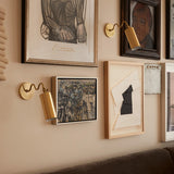 Bea Wall Sconce By Mitzi - Aged Brass on Wall around Portraits