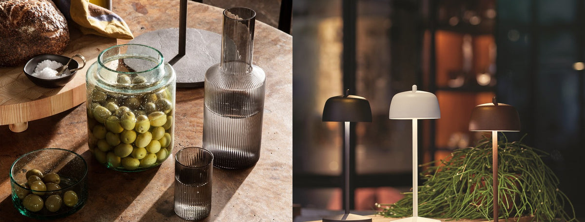 Designer glassware on a dining table and portable lamps on a dark shelf | Casa Di Luce