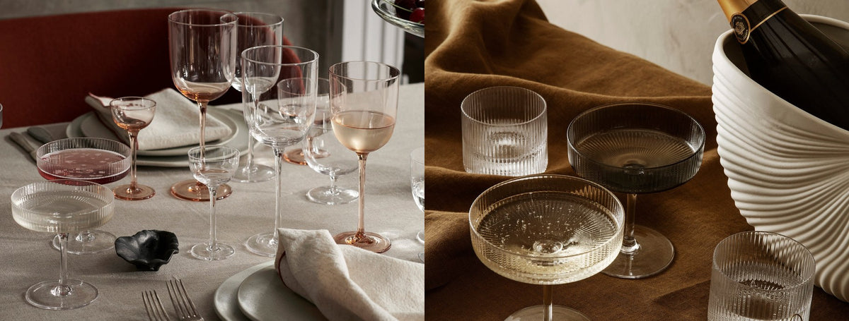 Wine glasses and champagne coupes on a set table beside a champagne cooler | Casa Di Luce