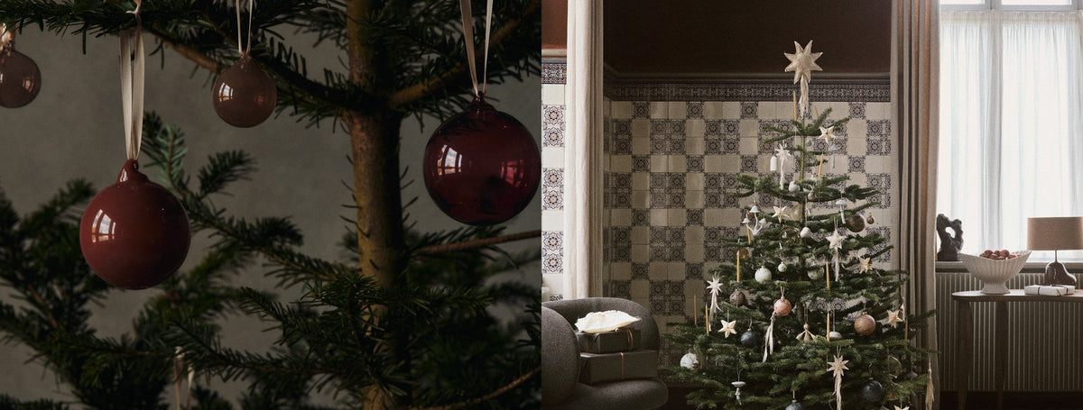 Red glass baubles hanging on a Christmas tree and a decorated tree in a living room | Casa Di Luce