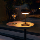 Bellboy Table Lamp - Anthracite, lit on an outdoor table