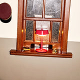 Bellboy Table Lamp - Lobby Red, lit in a window