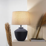 Buriti Table Lamp by Geo Contemporary in Navy Blue with a Rustic Linen shade on a console beside dried grasses