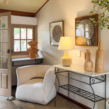 Búzios Table Lamp by Geo Contemporary lit on a wrought-iron console in a sunlit Brazilian guesthouse lounge