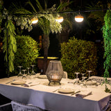 Conta Portable Lamp - Small, on a dining table at night