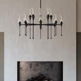 Chisel 16 Light Chandelier by Hudson Valley in Black Iron above a fireplace
