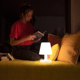 Edison The Petit Table Lamp - White, beside a reading nook