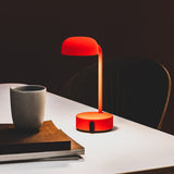 Fokus Battery Table Lamp - Orange, on a desk