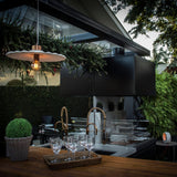 Guanabara Pendant Light by Geo Contemporary in White with copper fittings lit above an outdoor kitchen terrace at dusk