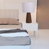 Ingá Table Lamp by Geo Contemporary in Brown with a White shade on a bedside table