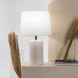 Jatobá Table Lamp by Geo Contemporary in White with a White shade, lit, on a console