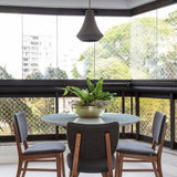 Juá Ceramic Pendant Light by Geo Contemporary above a round dining table on a glazed city balcony