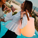 Kurby Play Portable Lamp - carried by its strap, coral glow