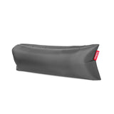 Inflatable grey lounger of lightweight ripstop fabric formed into an air-filled tube with a red Fatboy tab — Lamzac 3.0 by Fatboy