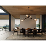 Locus Chandelier by Cerno with black accents over a dining table in a waterfront room