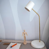 Lola Ceramic Table Lamp by Geo Contemporary with a gold stem on a desk beside a notebook