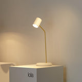 Lola Ceramic Table Lamp by Geo Contemporary with a gold stem, lit, on a display plinth