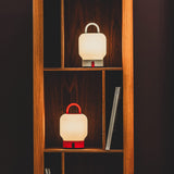 Loome Battery Table Lamp - Orange and Cloudy White, in a bookcase